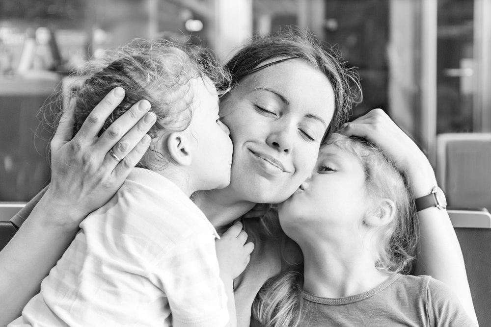 daughters kissing mom on cheeks