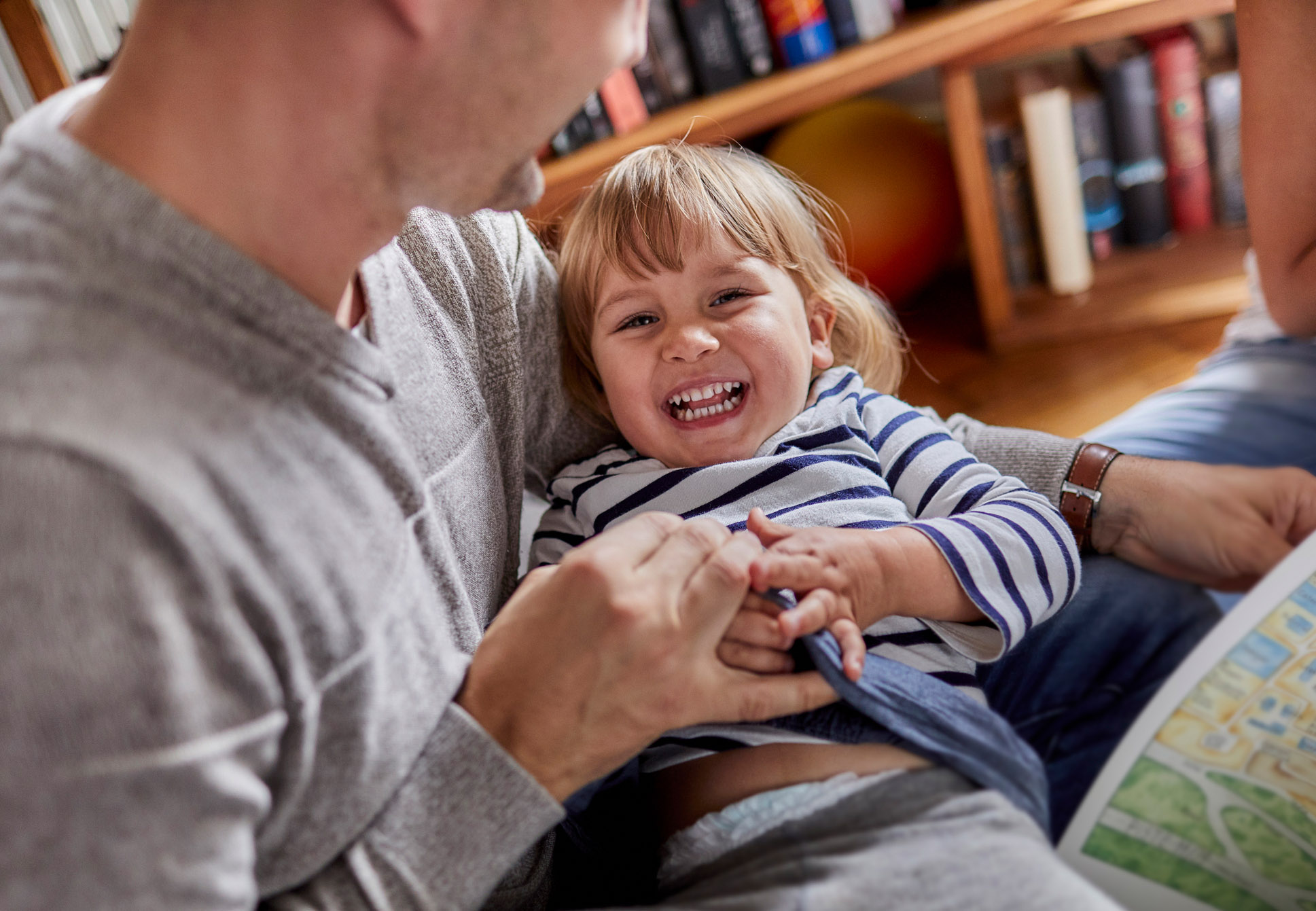 An image of a dad tickling his daughter.