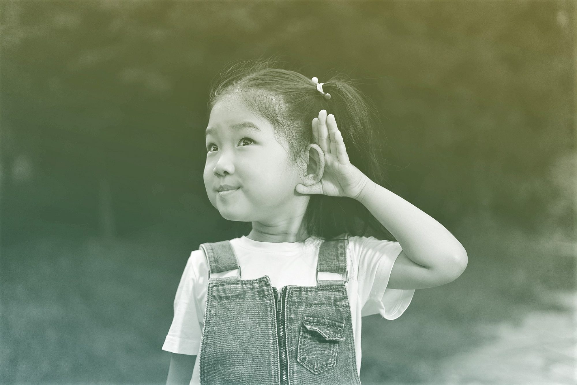 girl with her hands to her ear listening