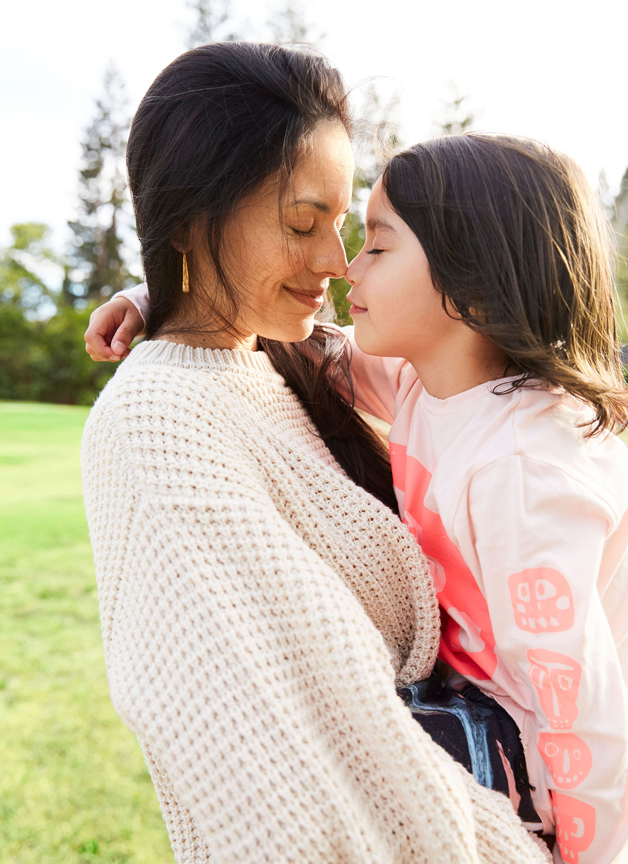 person holding child outside both smiling softly