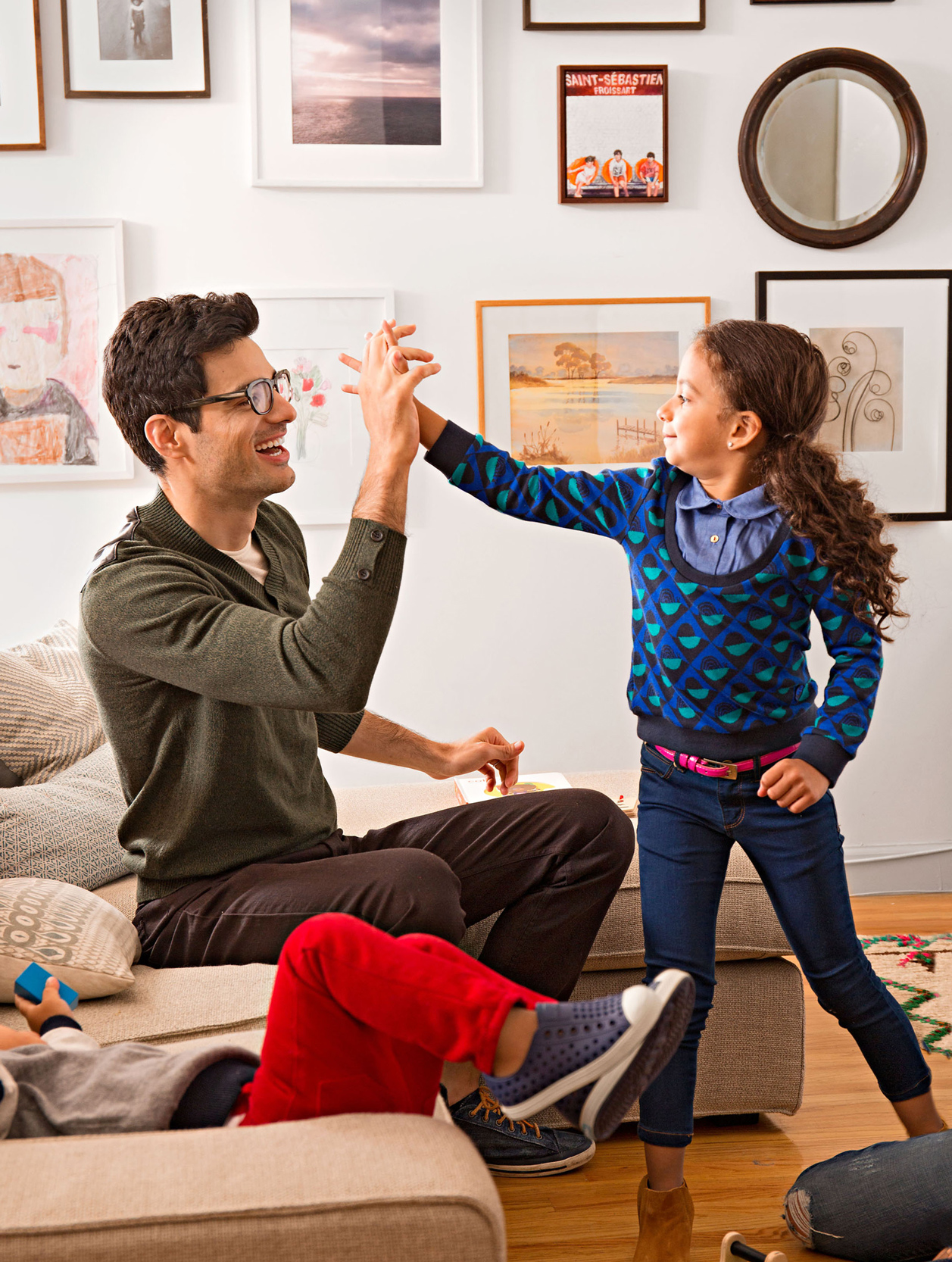 man smiling high-fiving a child