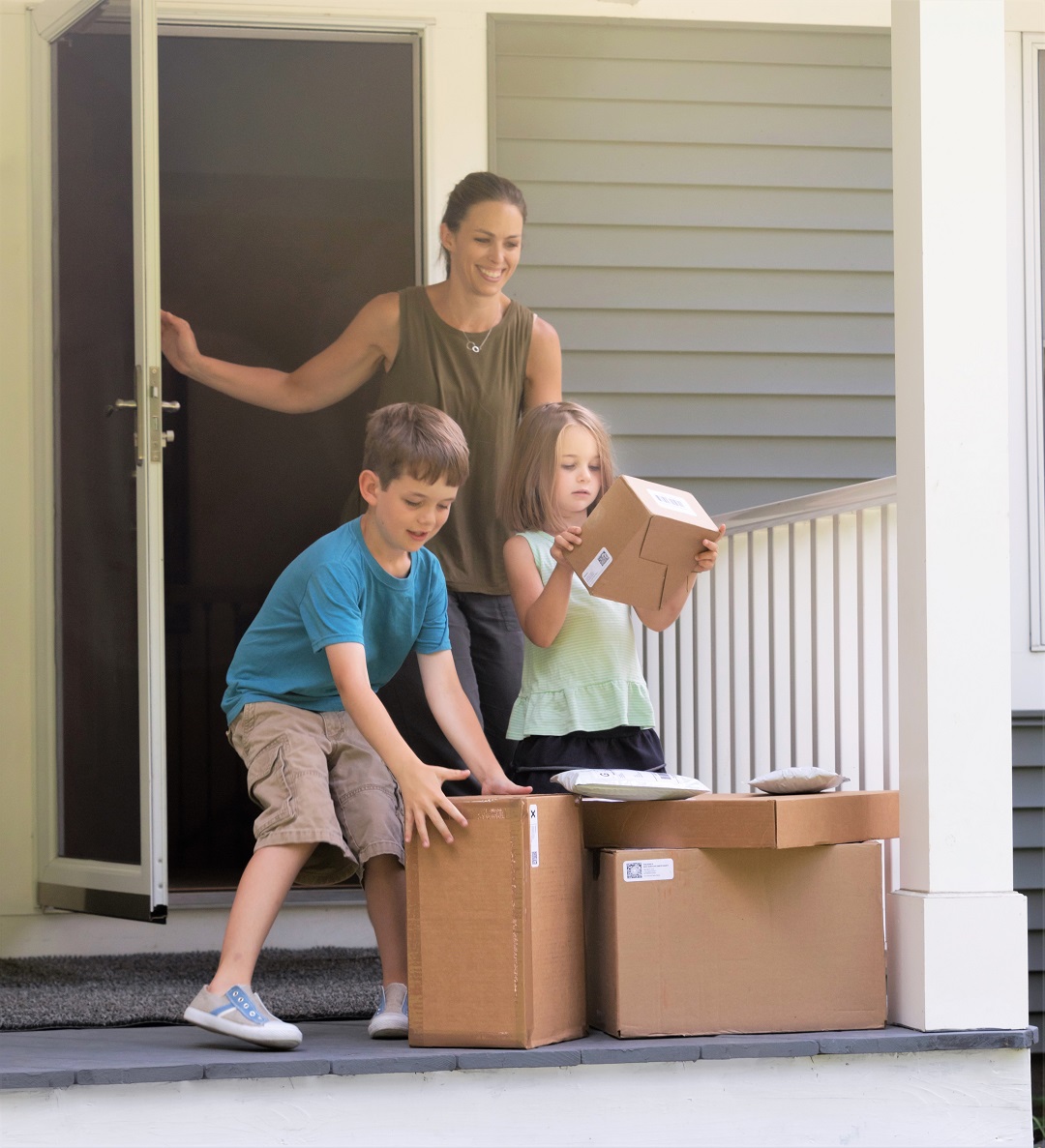 Children Getting Mailed Packages From Front Door