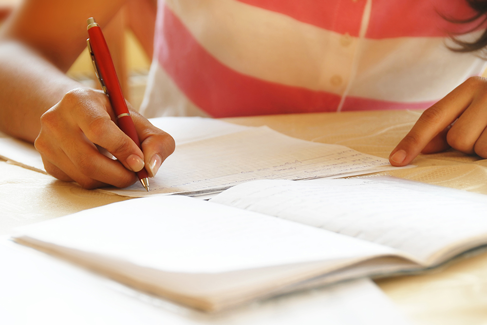 girl writes letter with pen