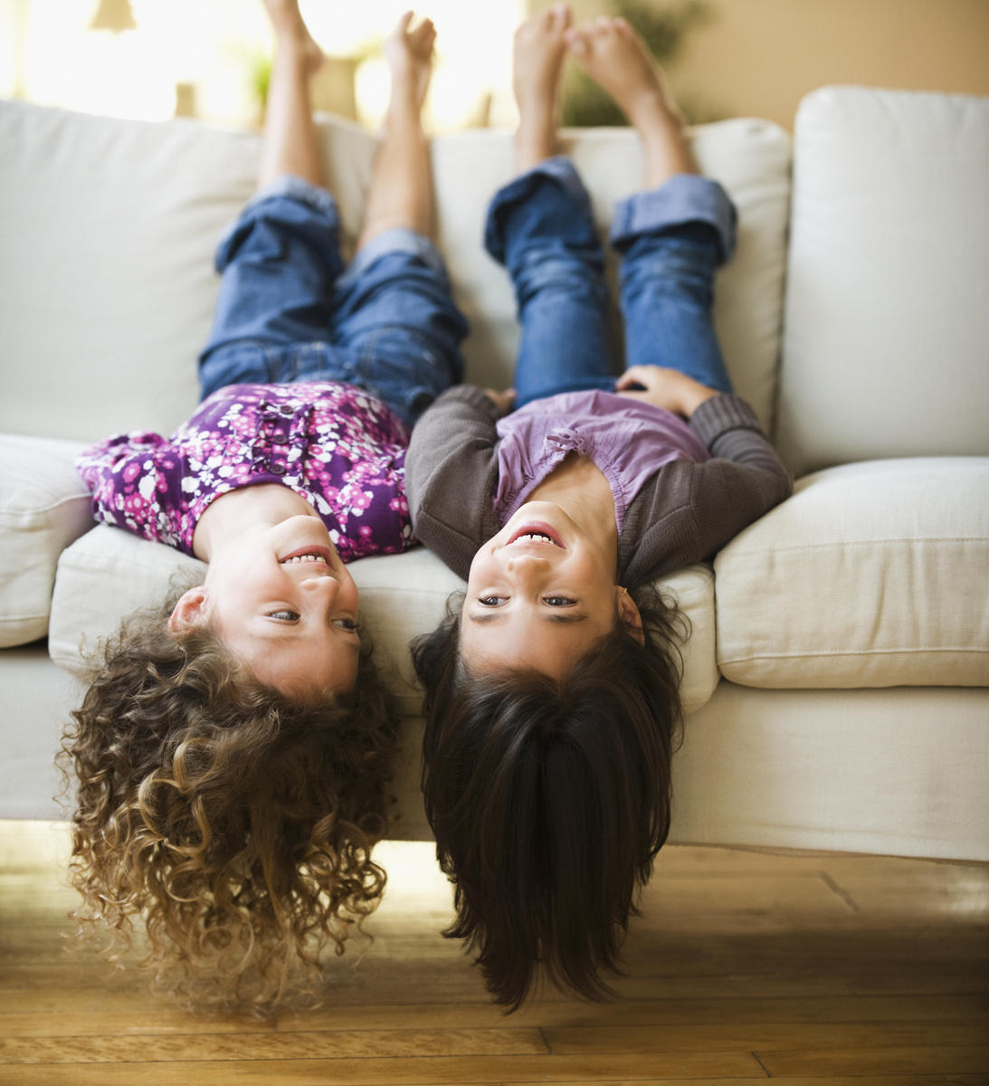 best friends laying upside-down on sofa