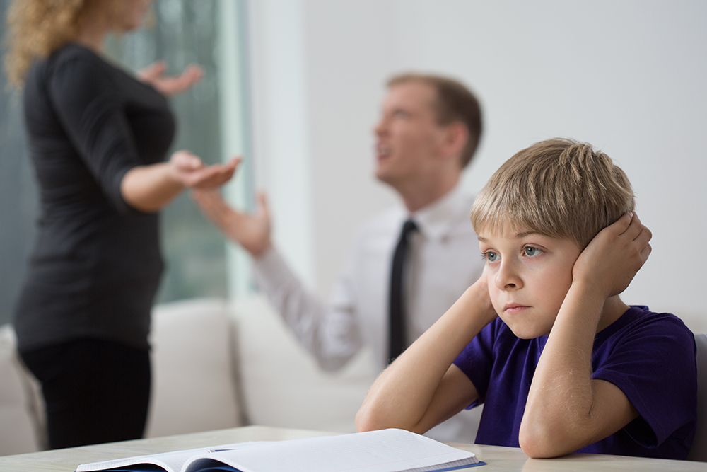 parents fighting behind son