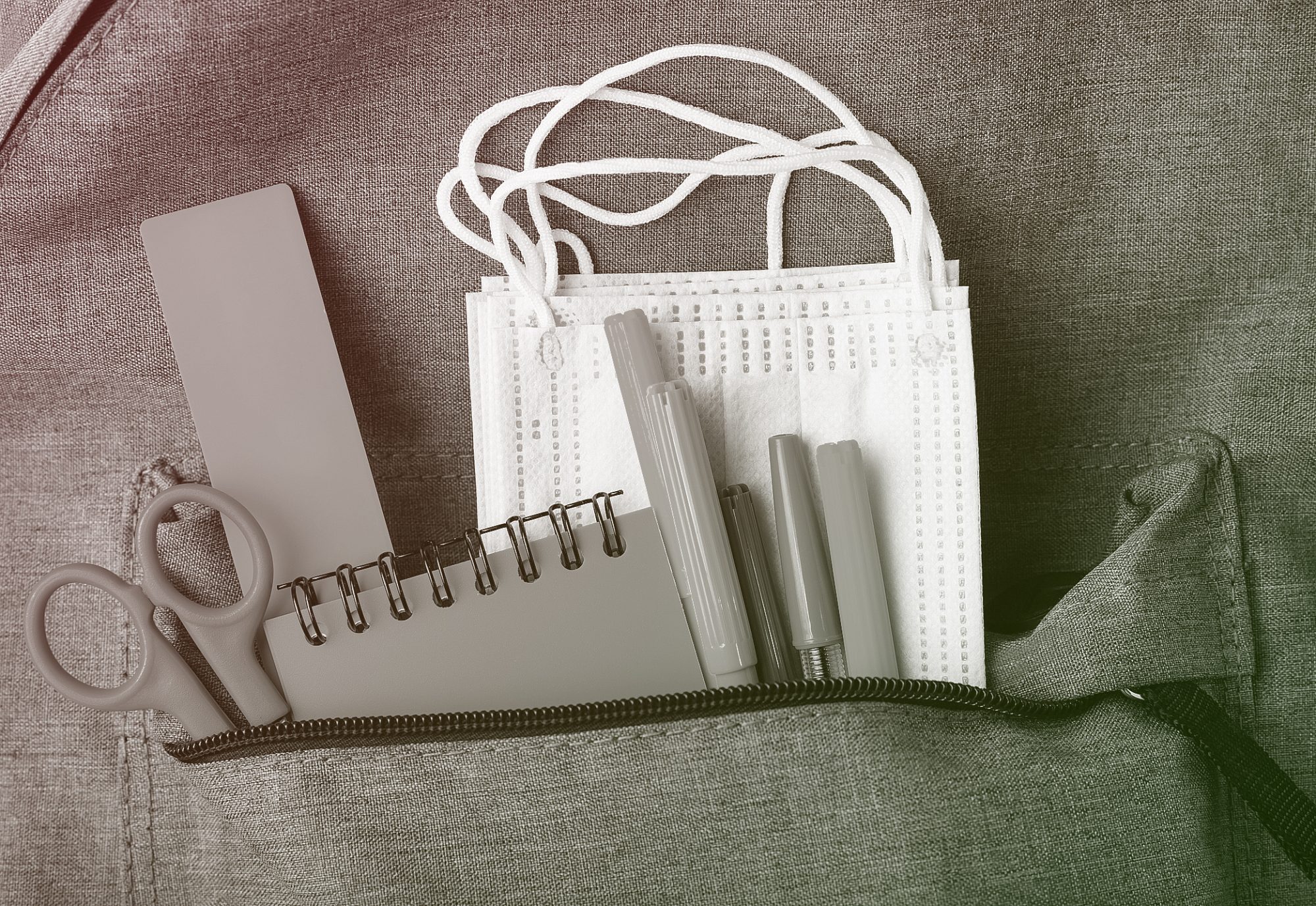 stationary supplies and face mask in backpack pocket