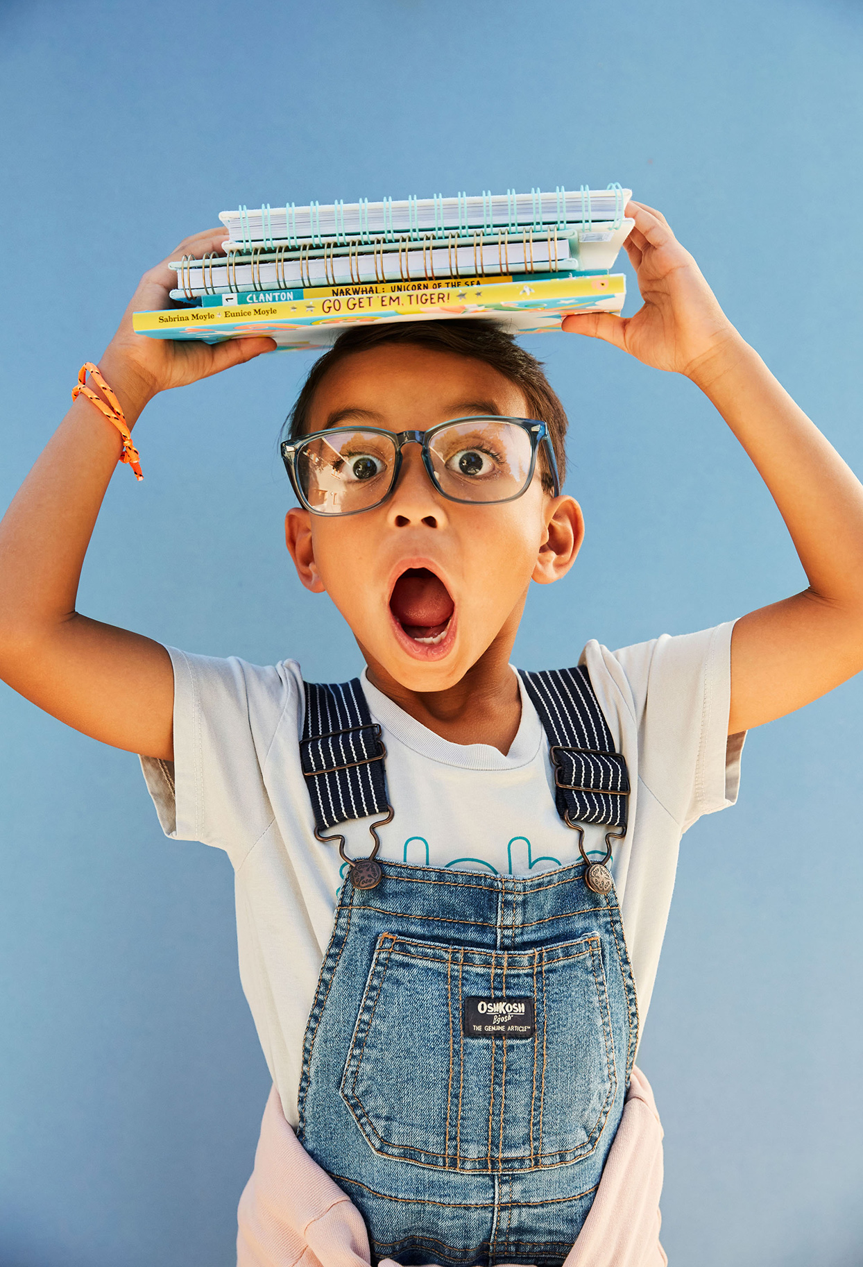 Child holding books on top of head