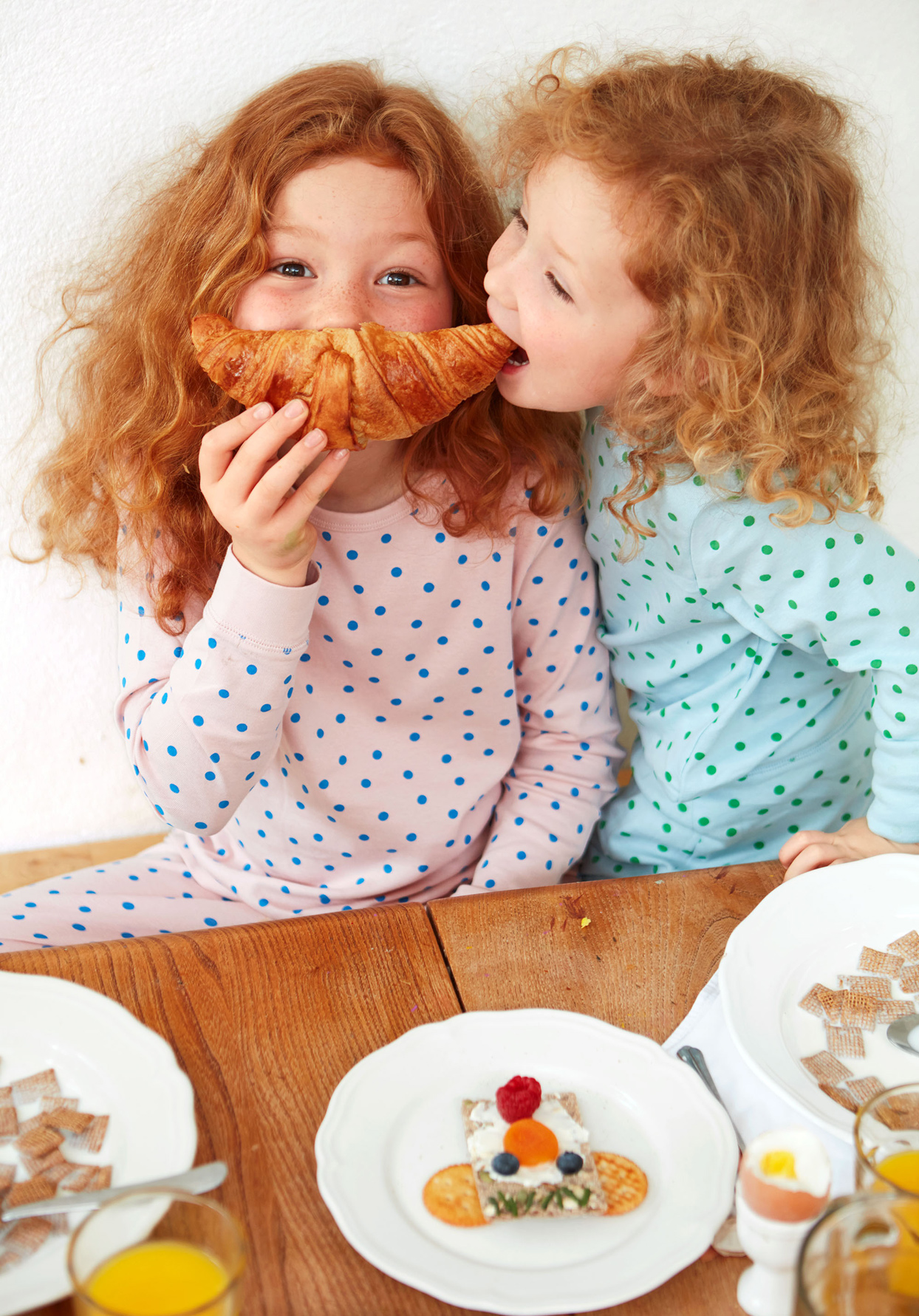 children wearing pajamas holding a crescent roll