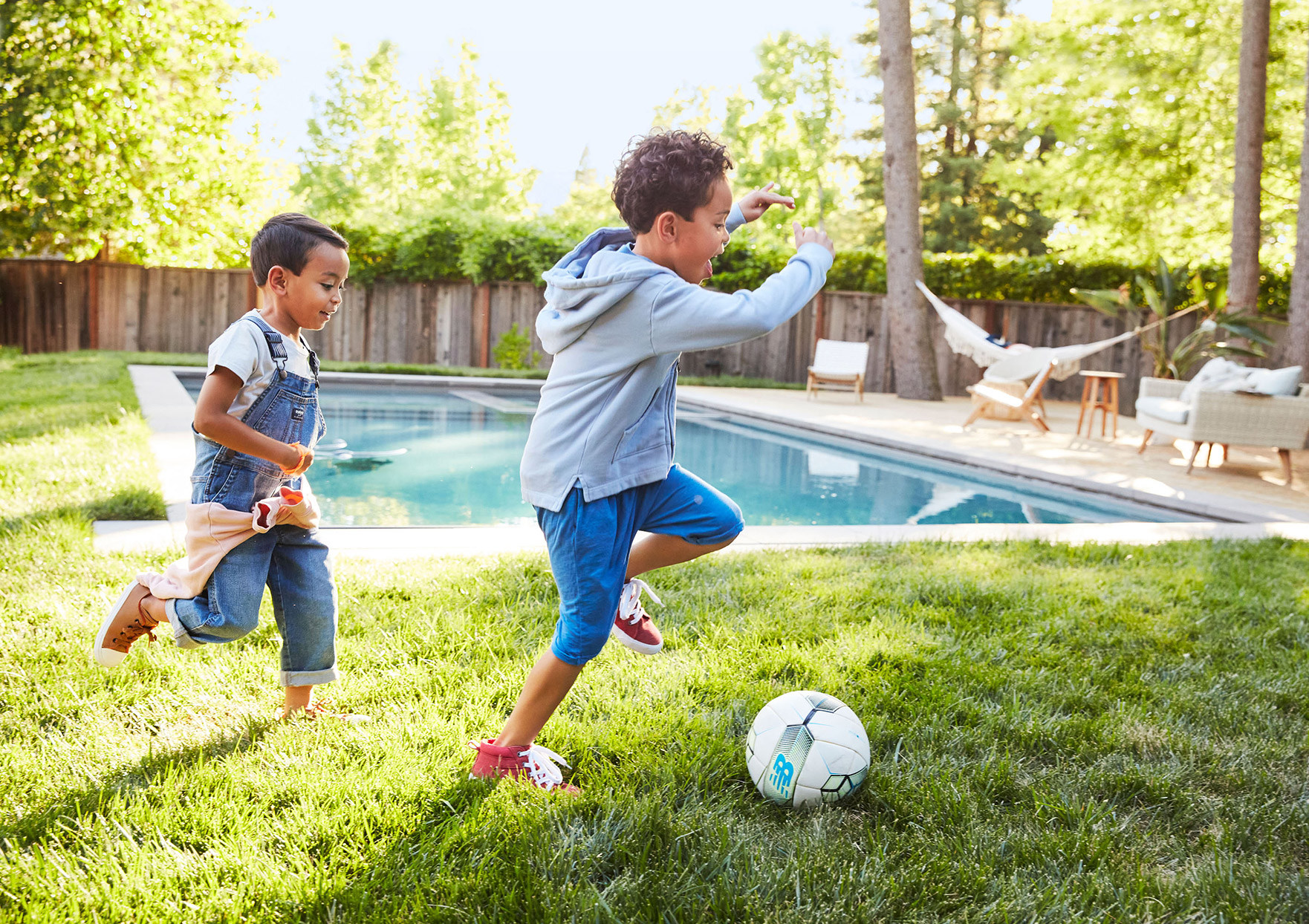 Children playing soccer near pool