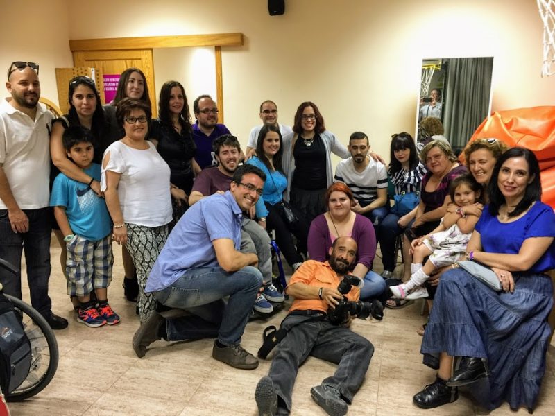 A large group of people face the camera for a group photo. This is a spina bifida group based in Murcia, Spain