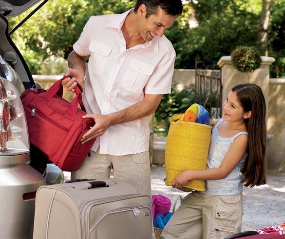 Man and child carrying luggage to a car - 11561