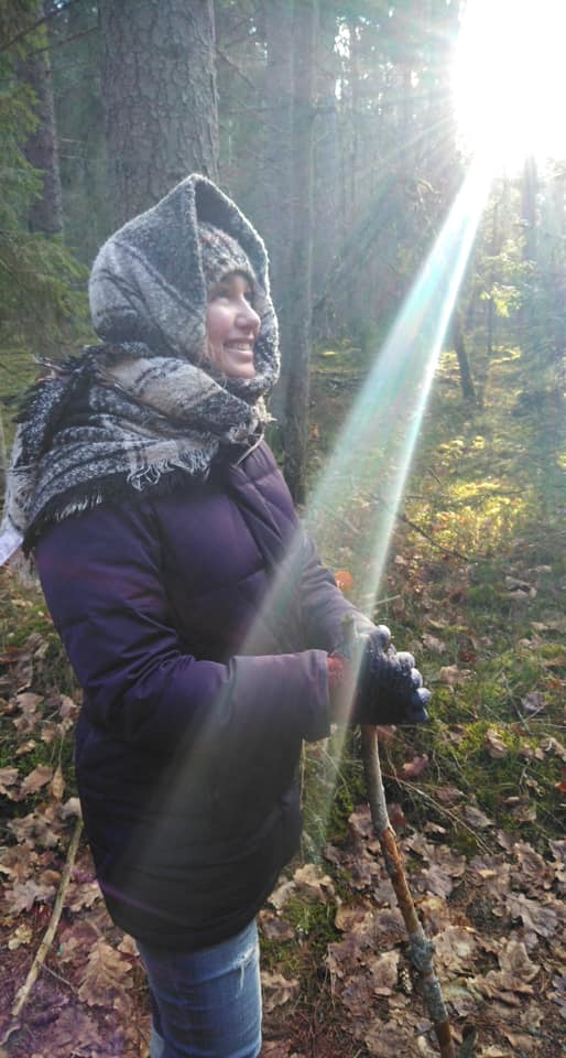 A hiker all bundled up to stay warm on an autumn hike with sun rays coming across the frame